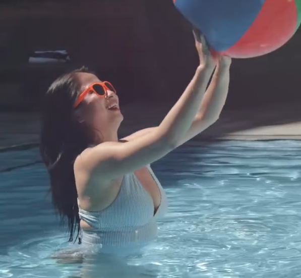 Girl playing with a beach ball in a pool